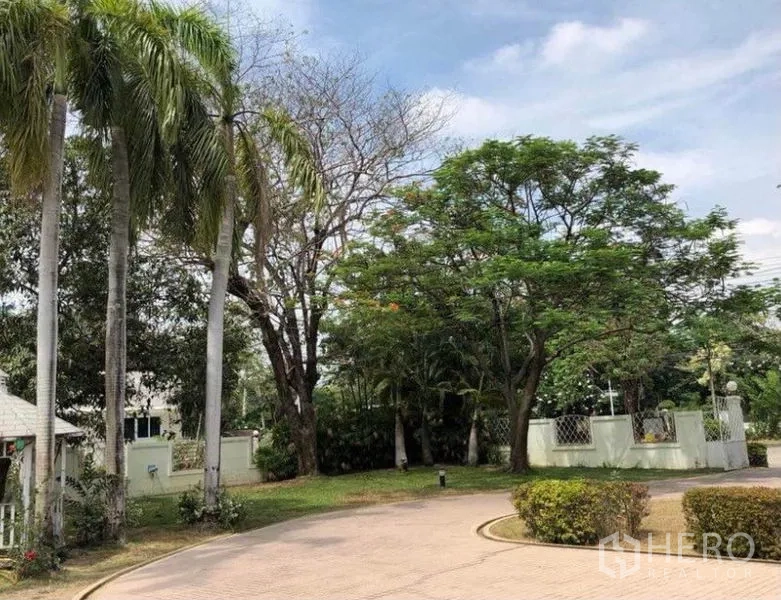 บ้าน ขายในMueang Samut Prakan, Samut Prakan - ถนนโค้งหน้าบ้านรายล้อมด้วยปาล์มและไม้ใหญ่ใกล้ประตูรั้ว