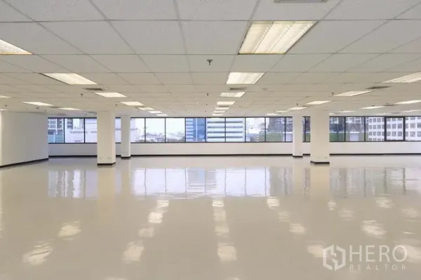 办公空间 出租在Bang Rak, Bangkok - 宽敞的开放式办公楼层，格栅吊顶与整排窗户俯瞰城市