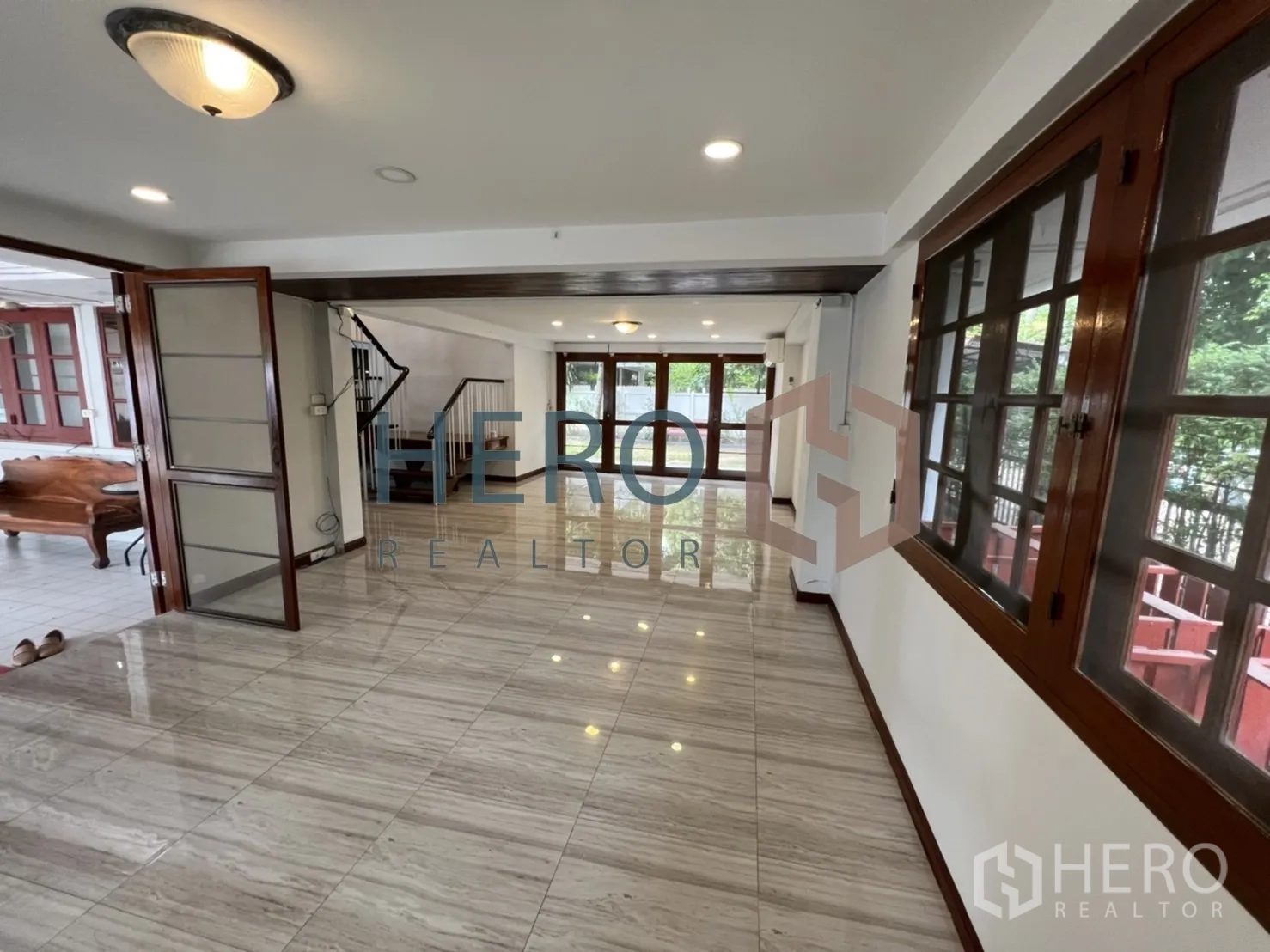 独立式住宅 出租在Watthana, Bangkok - 纵深客厅，木折叠门通向露台并连楼梯