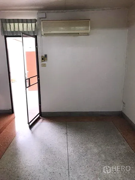 Townhouse for rent in Khlong Toei, Bangkok - Air‑conditioned room with door to balcony and terrazzo flooring.