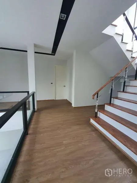 独立式住宅 出租在Phra Khanong, Bangkok - 木质踏步与玻璃扶手的楼梯间。