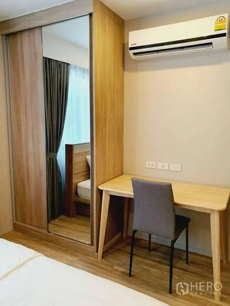 Condominium for rent in Sathon, Bangkok - Bathroom vanity with square basin, large mirror and warm wood panel.