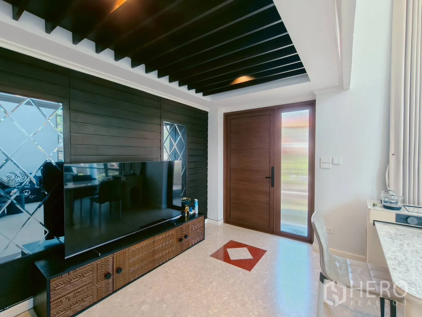 บ้าน ให้เช่าในLat Krabang, Bangkok - ห้องนั่งเล่น ตู้วางทีวีขนาดใหญ่ ฝ้าเพดานระแนงสีดำ และประตูไม้