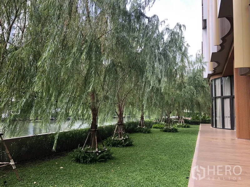 คอนโด ขายในWatthana, Bangkok - สนามหญ้าริมน้ำเรียงรายด้วยต้นหลิวข้างอาคารคอนโด