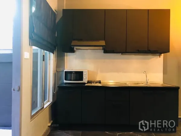 ทาวน์เฮาส์ ให้เช่าในBang Kapi, Bangkok - ครัวบิวท์อินโทนดำ มีเตาแก๊ส เครื่องดูดควัน อ่างล้างจาน และหน้าต่าง