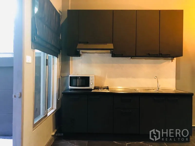 ทาวน์เฮาส์ ให้เช่าในBang Kapi, Bangkok - ครัวบิวท์อินโทนดำ มีเตาแก๊ส เครื่องดูดควัน อ่างล้างจาน และหน้าต่าง