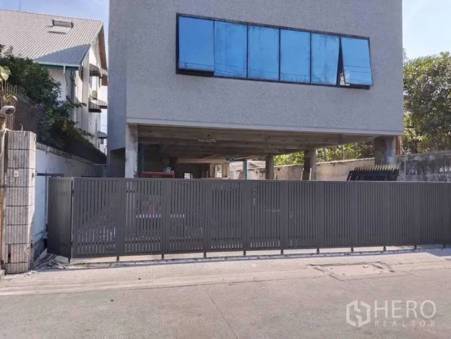 Home Office for rent in Phaya Thai, Bangkok - Front elevation of gated home office with cantilevered upper floors and blue-tinted windows.