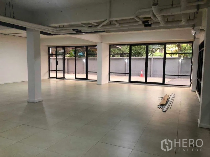 办公空间 出租在Phaya Thai, Bangkok - 转角工作区，环绕式玻璃可见前院空间。