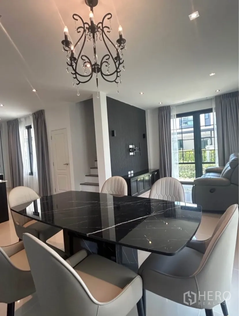 บ้านแฝด for rent in Bang Phli, Samut Prakan - พื้นที่รับประทานอาหารเชื่อมต่อโถงนั่งเล่น พร้อมโคมระย้า บันได และผนังตกแต่ง