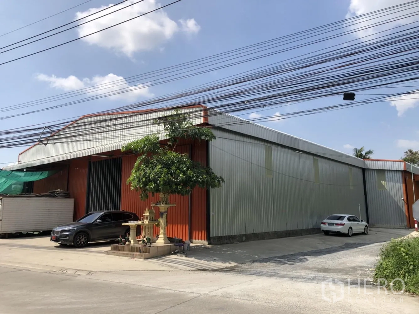 คลังสินค้า ให้เช่าในBang Kruai, Nonthaburi - มุมมองเฉียงของโกดังโครงเหล็กยาว พร้อมลานจอดรถหน้าอาคาร