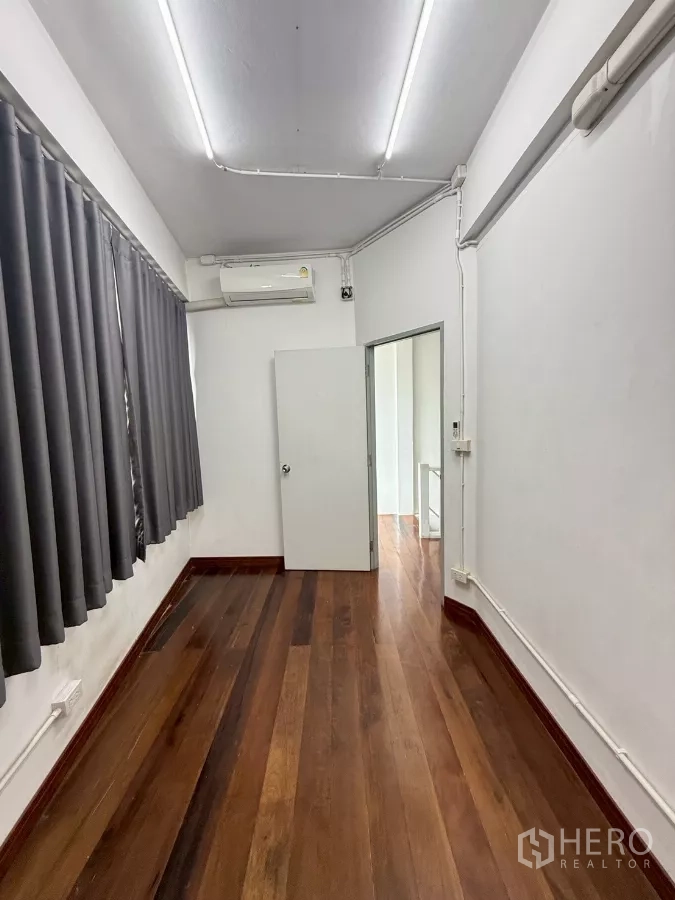 อาคารพาณิชย์ ให้เช่าในKhlong Toei, Bangkok - ห้องออฟฟิศขนาดกะทัดรัด พื้นไม้ โคมไฟยาว และผ้าม่านทึบ