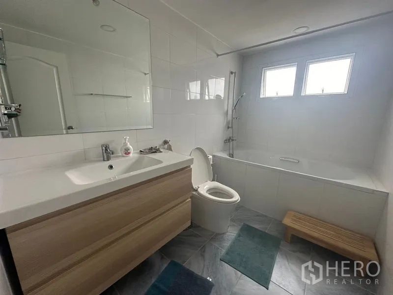 Condominium for rent - Another angle of the bathtub bathroom with large mirror and floor mats.