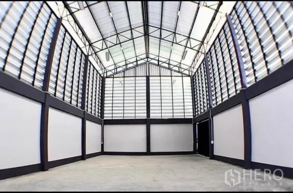 Factory for rent in Lat Lum Kaeo, Pathum Thani - High-ceiling warehouse interior with steel truss roof, louvered ventilation panels and a concrete floor.