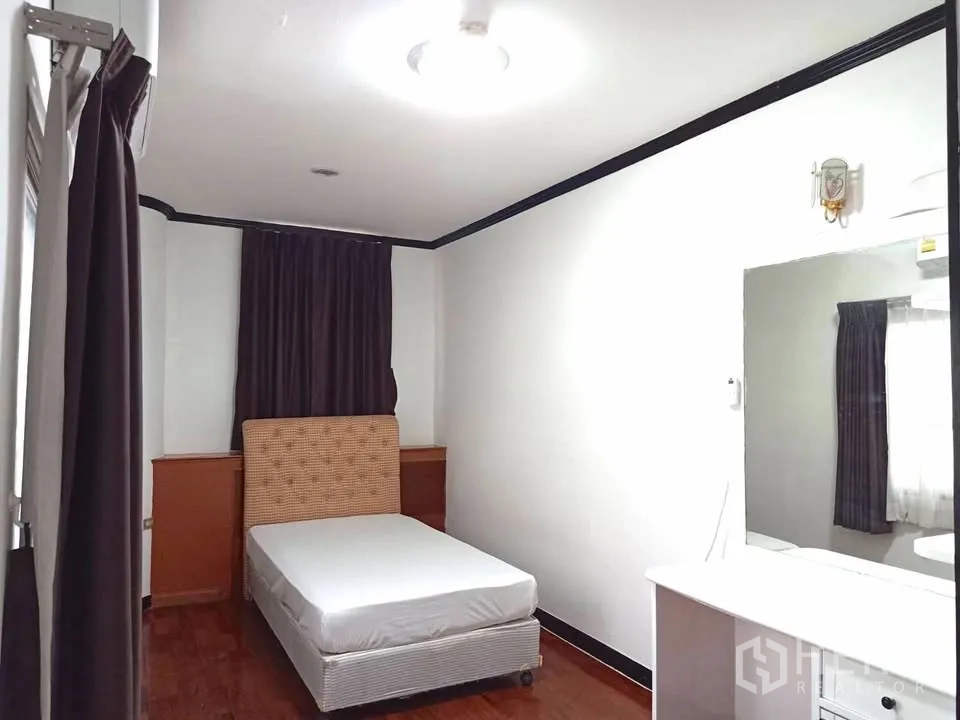 คอนโด for rent in Watthana, Bangkok - ห้องนอนขนาดพอเหมาะมีเตียงเดี่ยว โต๊ะเครื่องแป้ง และผ้าม่านสีเข้ม