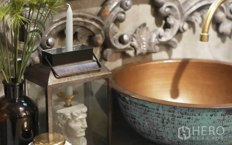 联排别墅 出租在Watthana, Bangkok - 浴室一隅：雕花镜、混凝土台面与狮头装饰水景。