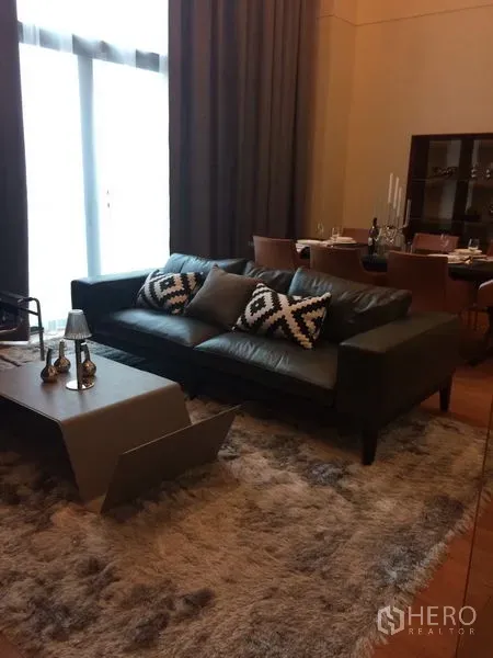 คอนโด ให้เช่าในKhlong Toei, Bangkok - ห้องนั่งเล่นสไตล์โมเดิร์น โซฟาหนัง พรมหนานุ่ม และโต๊ะกลางข้างชุดรับประทานอาหาร