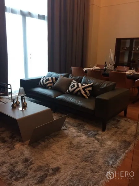 คอนโด ให้เช่าในKhlong Toei, Bangkok - ห้องนั่งเล่นสไตล์โมเดิร์น โซฟาหนัง พรมหนานุ่ม และโต๊ะกลางข้างชุดรับประทานอาหาร