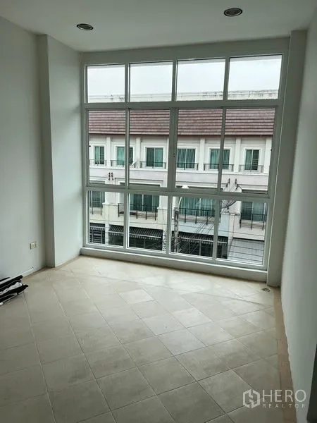 ทาวน์เฮาส์ ให้เช่าในSaphan Sung, Bangkok - ห้องเอนกประสงค์สว่างด้วยผนังกระจกสูง มองเห็นทาวน์เฮ้าส์ฝั่งตรงข้าม