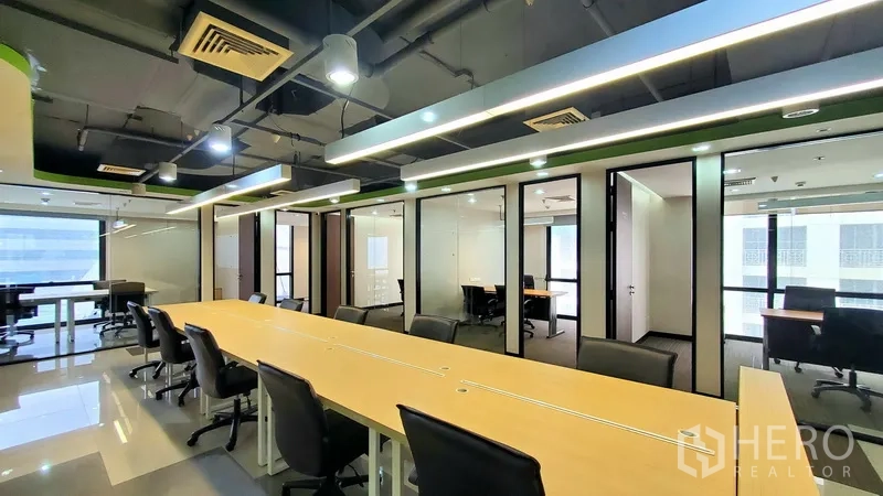 办公空间 出租在Watthana, Bangkok - 开放式办公室，长条工位，玻璃隔断办公室与线性灯光。