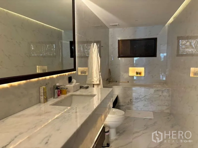 คอนโด ให้เช่าในWatthana, Bangkok - ห้องน้ำหินอ่อนมีอ่างอาบน้ำ กระจกบานใหญ่ และไฟสว่างนุ่มนวล