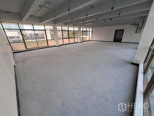 สำนักงาน ให้เช่า - พื้นที่ออฟฟิศกว้างแบบไม่ตกแต่ง มีกระจกมุมขนาดใหญ่ เหมาะจัดผังโต๊ะทำงานได้หลากหลาย