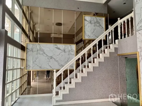 พื้นที่ขายปลีก ให้เช่าในKhlong Toei, Bangkok - โถงต้อนรับเพดานสูง ผนังกระจกเงา ลายหินอ่อน และบันไดตกแต่งสีขาว