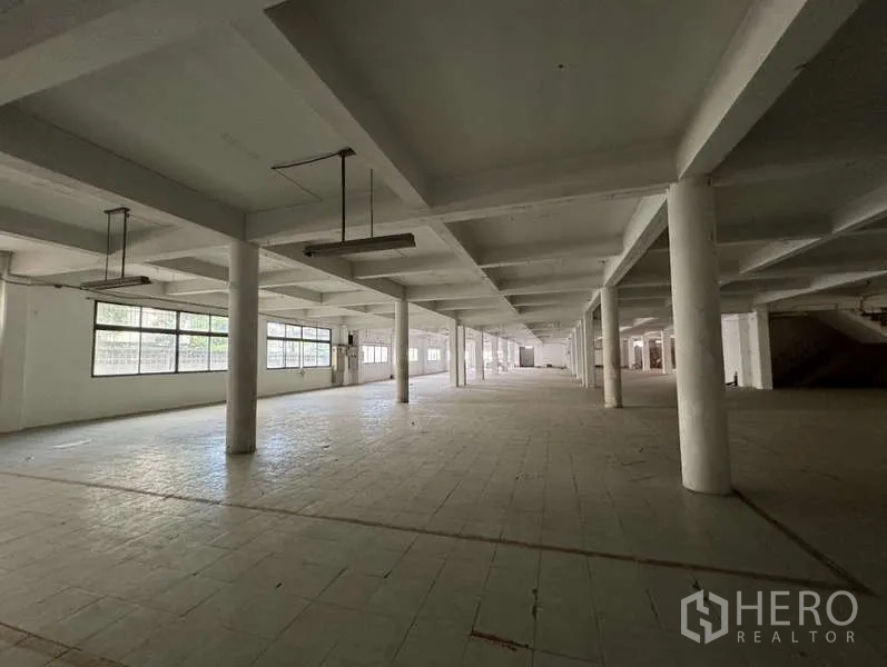 Home Office for sale in Bang Na, Bangkok - Long unobstructed hall suitable for storage or production, tiled floor and grid ceiling.