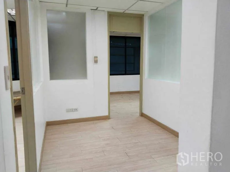 办公空间 出租在Bang Na, Bangkok - 入口走廊通向封闭办公室，配内置玻璃与木地板。