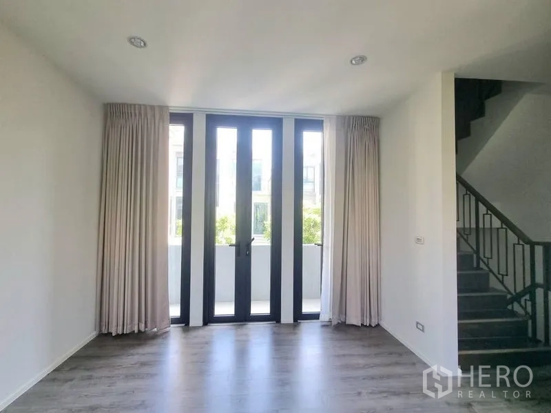 独立式住宅 出租 - 起居区设高挑玻璃门通往阳台，旁边是楼梯。