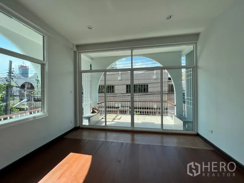 带办公室的家 出租在Watthana, Bangkok - 采光充足的起居区，落地玻璃门通往拱形露台。
