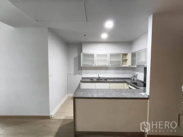 คอนโด ให้เช่าในKhlong Toei, Bangkok - ครัวรูปตัว U เคาน์เตอร์หินแกรนิต อ่างล้าง เตา และตู้แขวนบานกระจก