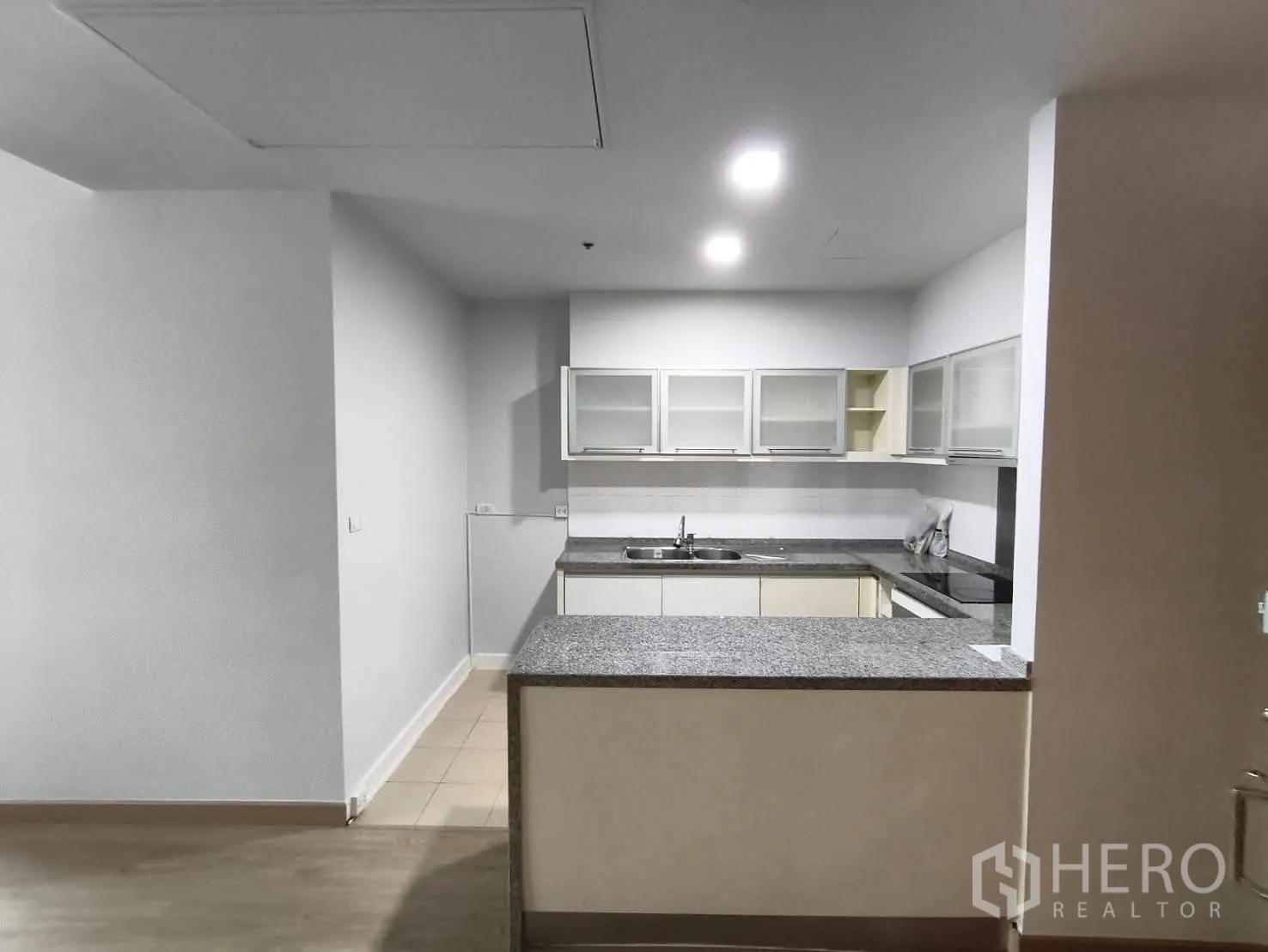 คอนโด ให้เช่าในKhlong Toei, Bangkok - ครัวรูปตัว U เคาน์เตอร์หินแกรนิต อ่างล้าง เตา และตู้แขวนบานกระจก