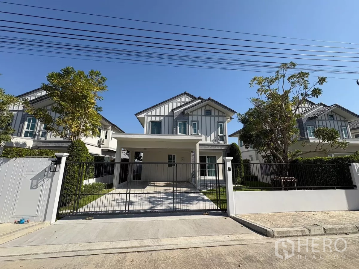 Detached House for rent in Bang Phli, Samut Prakan - Modern two-storey detached house with gated driveway and lawn in a secure community.