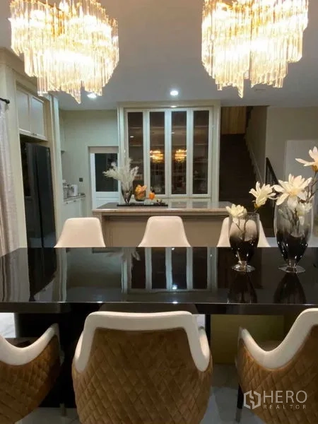 独立式住宅 出租在Bang Khen, Bangkok - 餐厅设黑色亮面餐桌、软包餐椅与水晶吊灯。