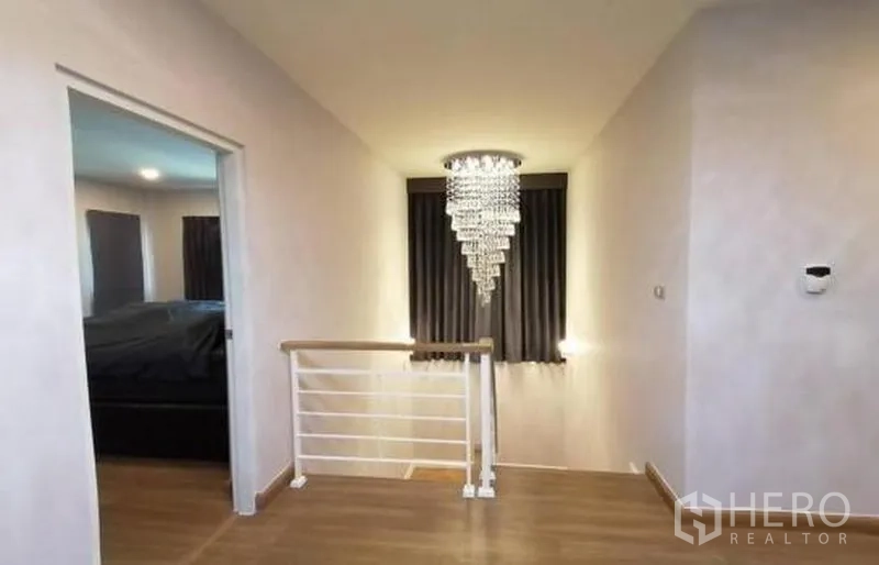 Detached House for sale in Bang Phli, Samut Prakan - Upstairs landing with wood flooring, stair rail and statement crystal chandelier.