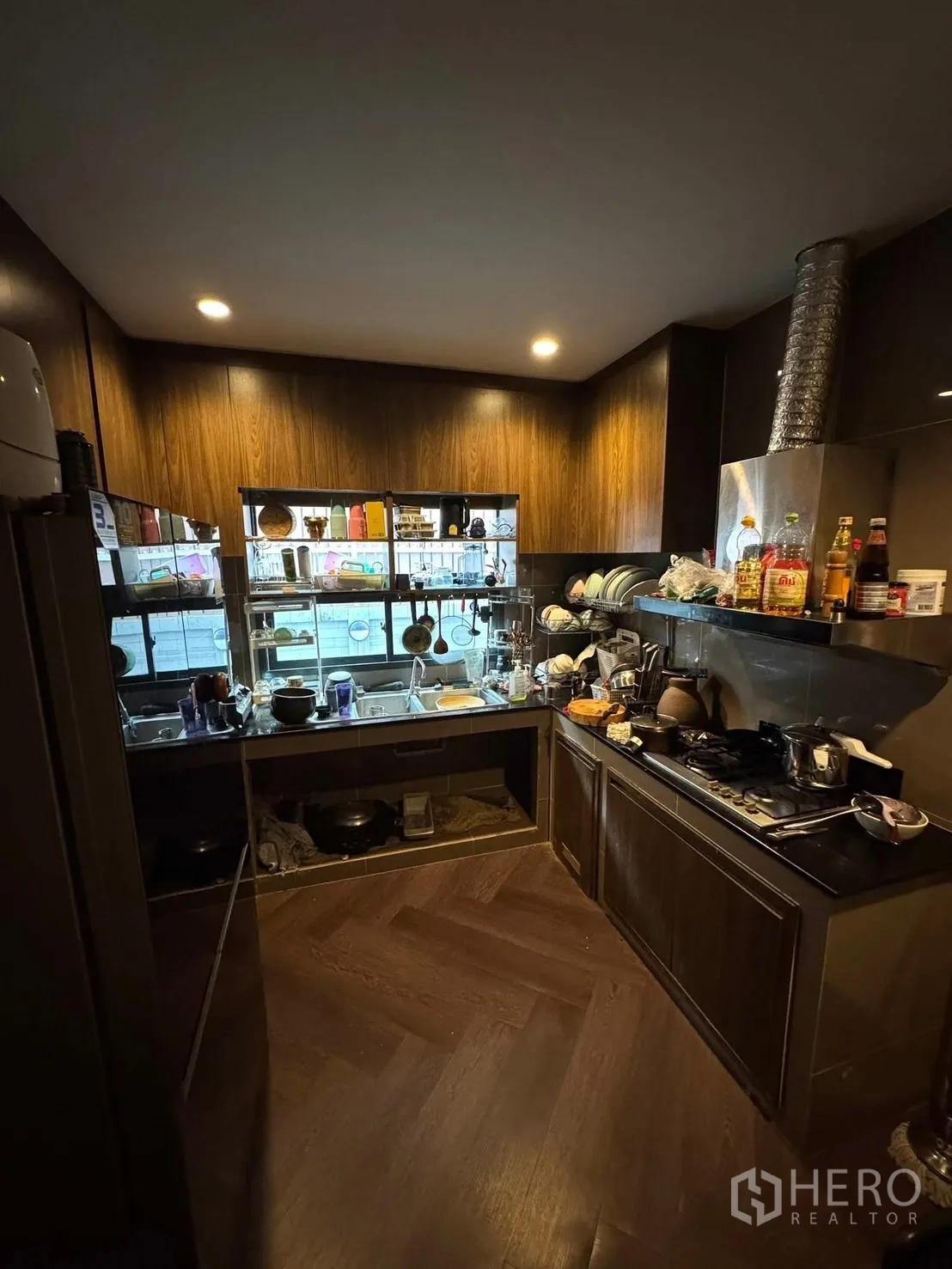 独立式住宅 出售在Mueang Pathum Thani, Pathum Thani - 封闭式泰式厨房，燃气灶、烟机与深色橱柜。