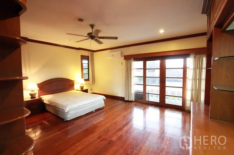 บ้าน ให้เช่าในPrawet, Bangkok - ห้องนอนกว้าง พัดลมเพดาน พื้นไม้ และประตูกระจกฝรั่งเศสเปิดออกสู่ระเบียง