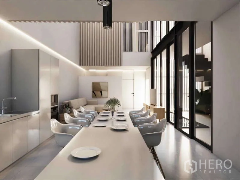 Home Office for rent in Bang Phli, Samut Prakan - Double-height open-plan kitchen, dining and living area with a long meeting table and floor-to-ceiling windows.