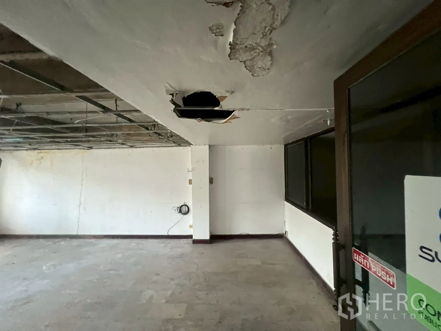 店屋 出租在Phra Khanong, Bangkok - 未完工天花细节及带玻璃门的空置房间。