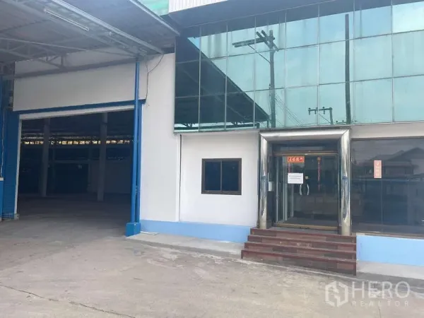 Warehouse for rent in Nong Khaem, Bangkok - Glass-fronted office attached to the warehouse beside a large loading door.