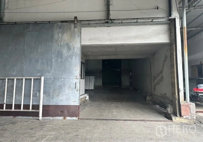 Warehouse for rent in Lat Krabang, Bangkok - Large sliding metal door and loading ramp at the warehouse entrance.