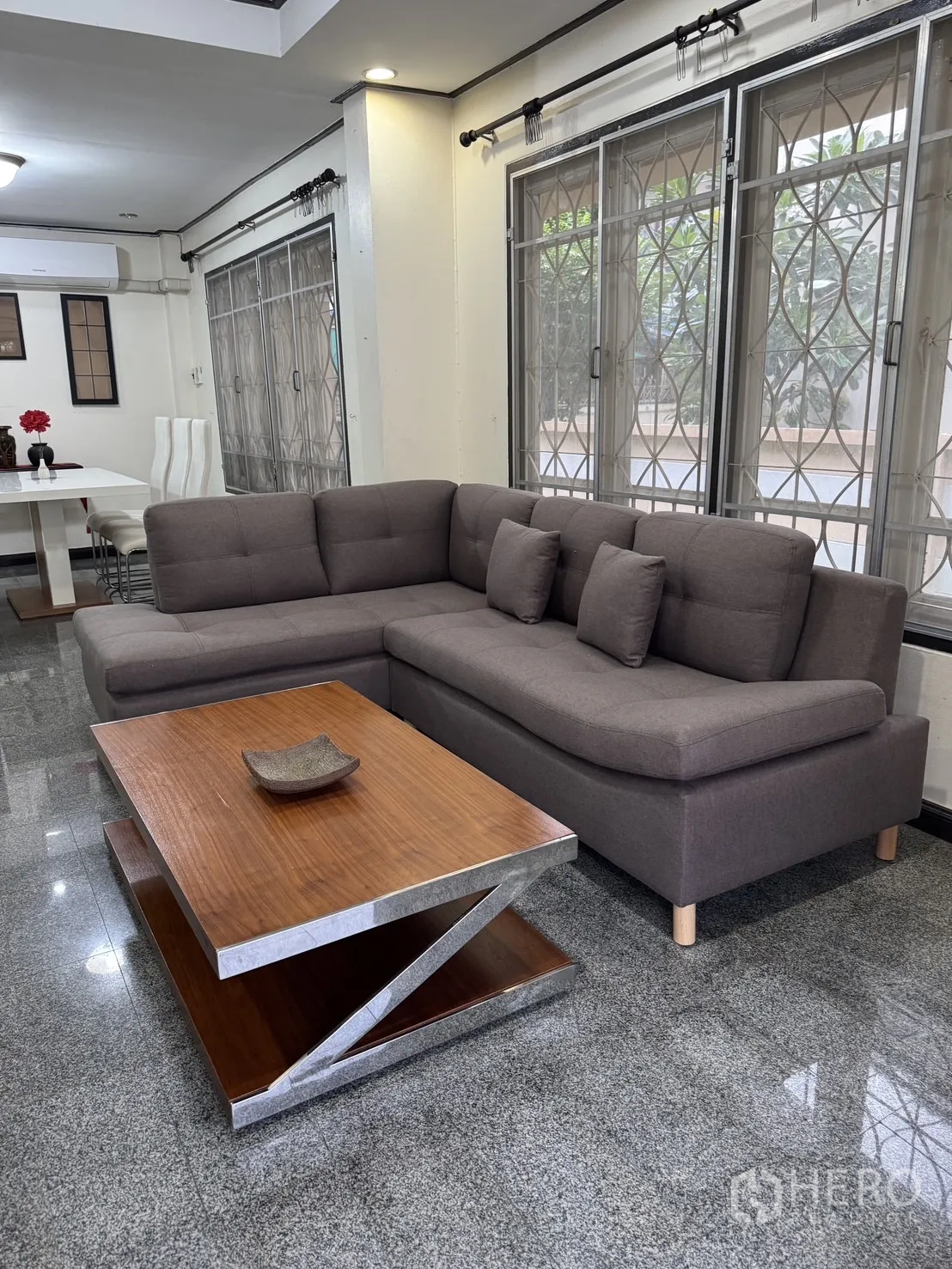 บ้าน ให้เช่าในMin Buri, Bangkok - มุมนั่งเล่นโซฟาเข้ามุม โต๊ะกลางไม้ และหน้าต่างบานใหญ่พร้อมเหล็กดัด