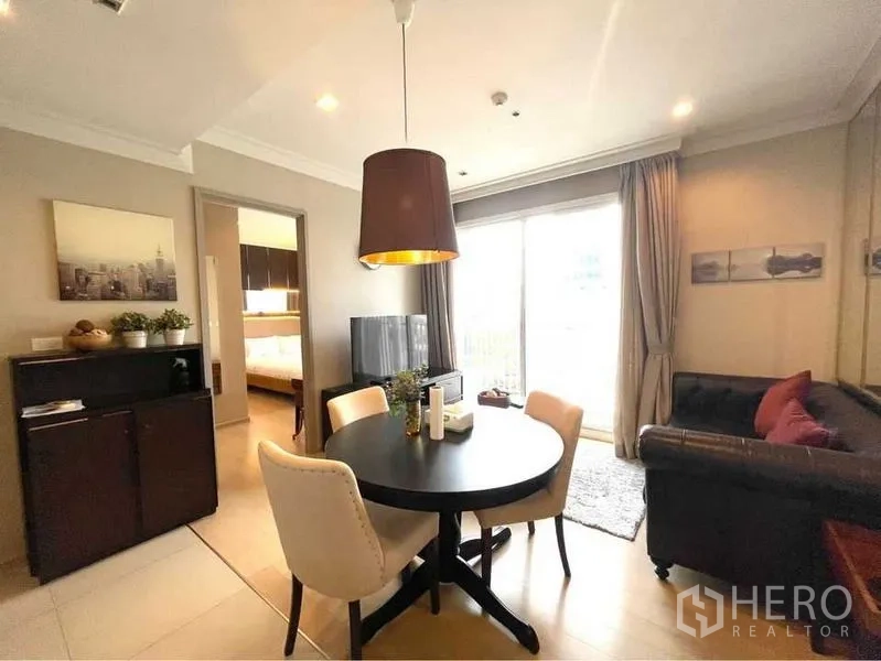 คอนโด ให้เช่าในWatthana, Bangkok - ห้องนั่งเล่นและรับประทานอาหารสว่างโปร่ง โต๊ะกลม โคมไฟ โซฟา ทีวี และประตูกระจกออกระเบียงในคอนโดทองหล่อ