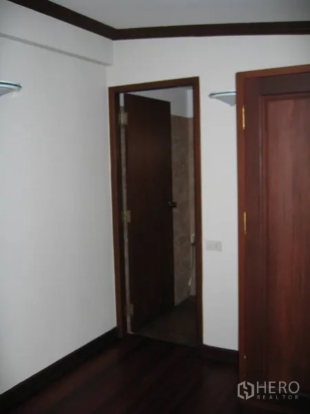 บ้าน ให้เช่าในWatthana, Bangkok - ประตูห้องเล็กเชื่อมเข้าสู่ห้องน้ำ ข้างตู้เสื้อผ้าไม้