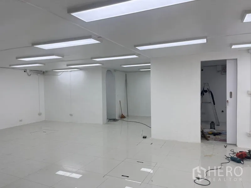 零售空间 出租在Khlong Toei, Bangkok - 店铺一角，带门与拱形壁龛，顶灯照明。