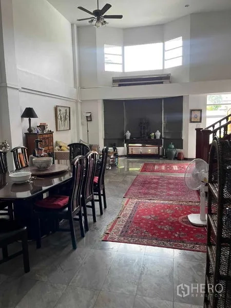 Home Office for rent in Bang Rak, Bangkok - Dining area connected to living space, red carpets and prominent wooden staircase.