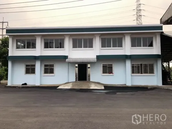 โรงงาน ให้เช่าในLam Luk Ka, Pathum Thani - ด้านหน้าอาคารสำนักงาน 2 ชั้นทาสีใหม่ พร้อมช่องหน้าต่างและเหล็กดัด