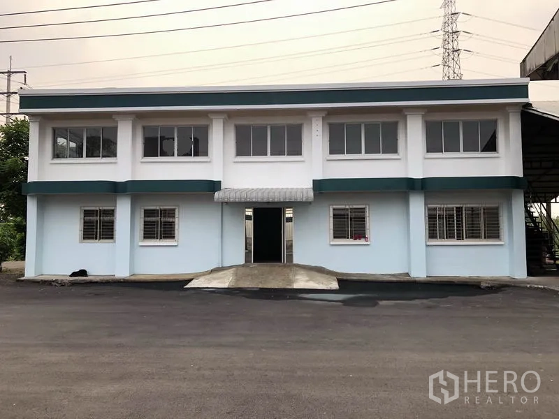 โรงงาน ให้เช่าในLam Luk Ka, Pathum Thani - ด้านหน้าอาคารสำนักงาน 2 ชั้นทาสีใหม่ พร้อมช่องหน้าต่างและเหล็กดัด