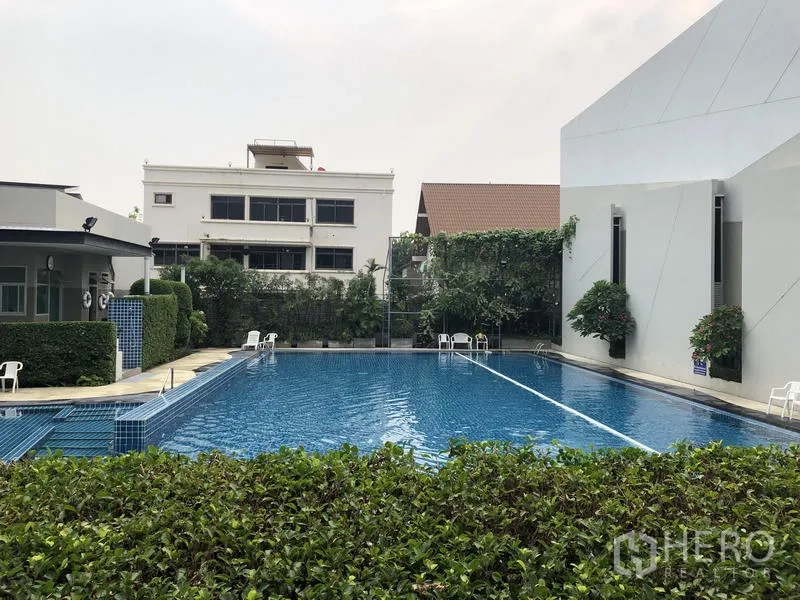 Detached House for rent in Suan Luang, Bangkok - Community swimming pool with seating and landscaped hedges