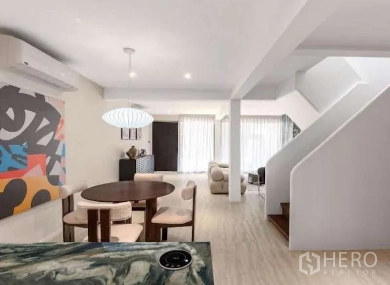 Townhouse for sale in Sathon, Bangkok - Dining corner with round table, pendant light and bright glazing.